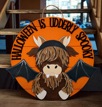 Load image into Gallery viewer, Halloween sign with a Highland Cow in a bat costume and 'Halloween is Udderly Spooky' text on an orange background.