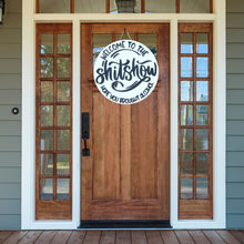 Load image into Gallery viewer, A wooden door hanger sign with the text 'Welcome to the Shitshow, Hope You Brought Alcohol' in a circular, decorative font.