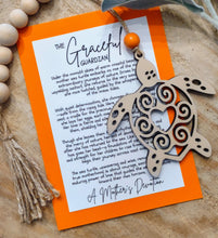 Load image into Gallery viewer, A decorative sea turtle charm ornament with a heart pattern in the center, accompanied by a keepsake card honoring a mother's love and devotion.
