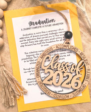 Load image into Gallery viewer, Wood ornament featuring Class of 2026 and words of positivity to describe the graduate, such as accomplished, ambitious, motivated, optimistic, etc. 
