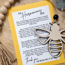 Load image into Gallery viewer, A wooden ornament in the shape of a bee with a keepsake story card that compares the collaboration and teamwork of bees in building a hive to a productive work culture. Includes a thank you message for being part of the hive.
