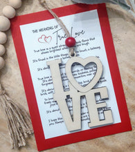 Load image into Gallery viewer, Wooden ornament spelling out the word LOVE in a stacked fashion with a keepsake card referencing unconditional love.
