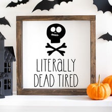 Load image into Gallery viewer, A wooden painted sign with a skull and crossbones symbol, and the text 'Literally Dead Tired' on a home decor background with Halloween decorations.
